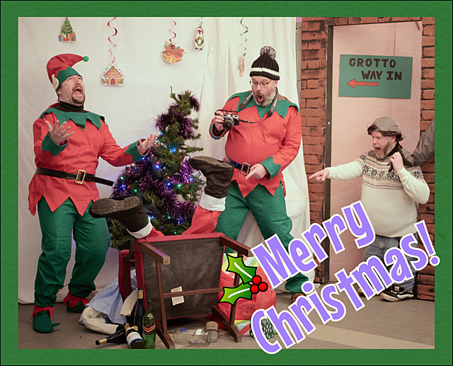 A ‘Santa’s’ grotto with Santa collapsed, his helpers looking shocked and a small boy pointing at him.