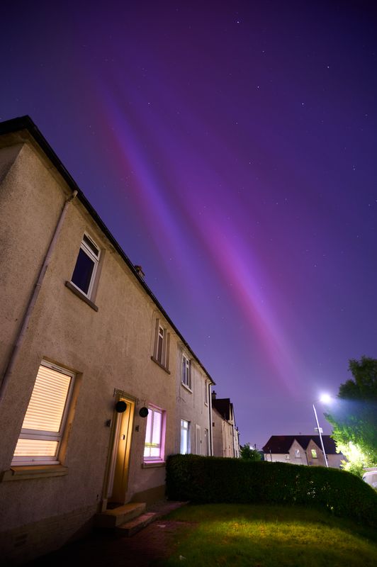 Block of flats with purple aurora above it.