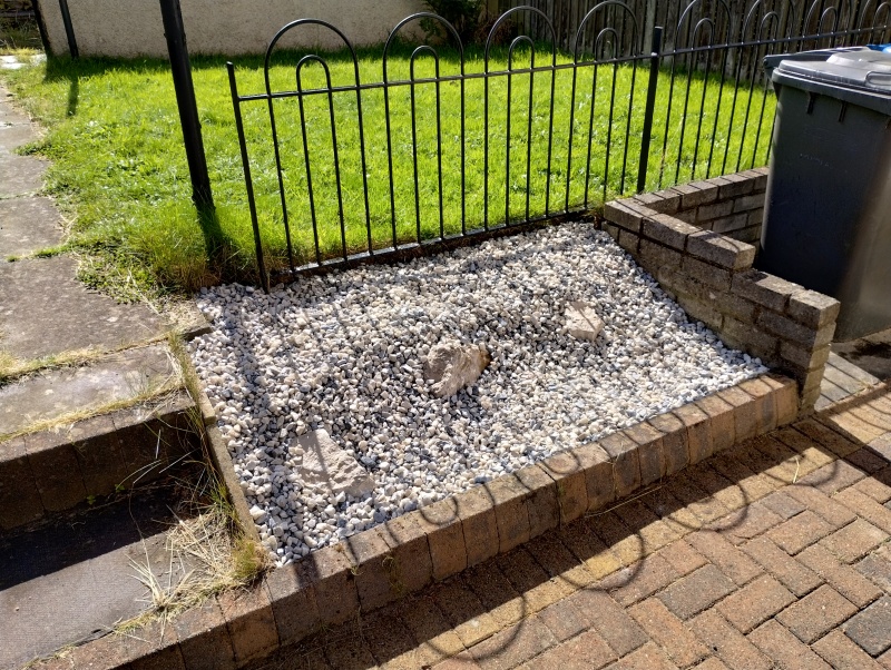 A gravel covered area with some stones sticking out
